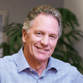 A man in a blue shirt is smiling for the camera.