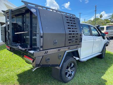 A White Truck with A Black Canopy Is Parked in The Grass — PSE Stainless Steel Fabrications in Manunda, QLD