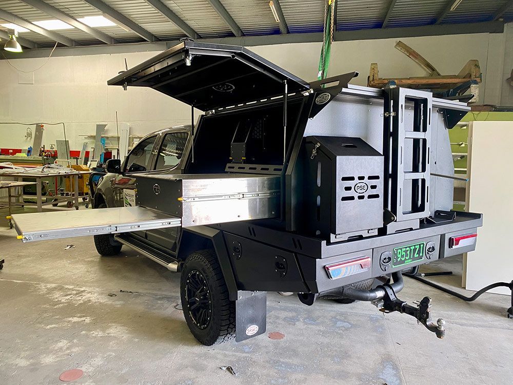 A truck with a trailer attached to it is parked in a garage  — PSE Stainless Steel Fabrications in Manunda, QLD