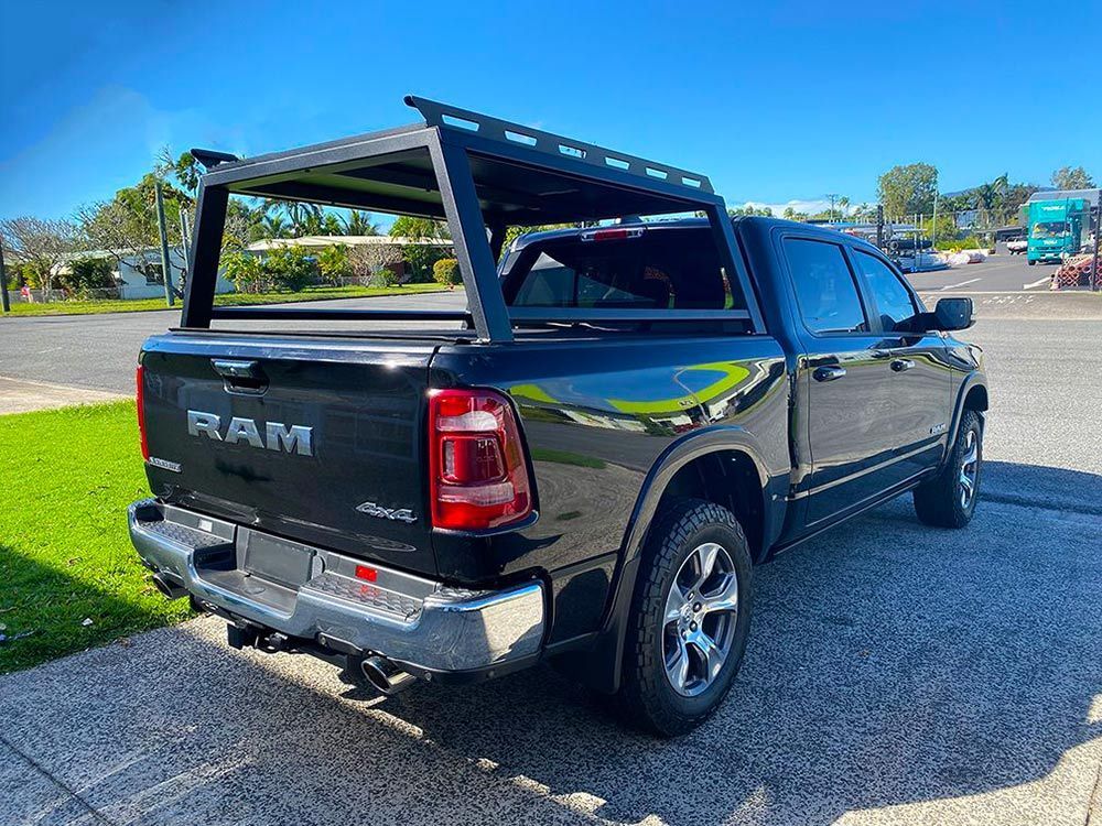 A black ram truck with a rack on top of it is parked on the side of the road — PSE Stainless Steel Fabrications in Manunda, QLD