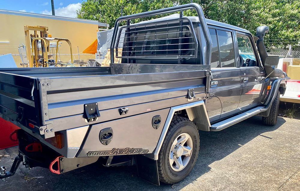 A truck with a tray bed is parked on the side of the road — PSE Stainless Steel Fabrications in Manunda, QLD