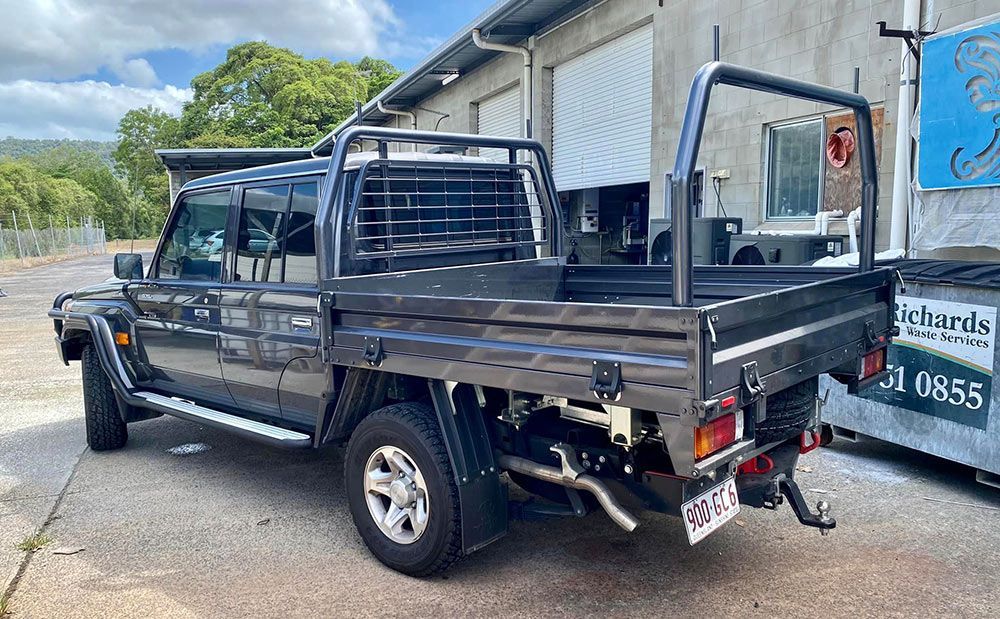 A Truck with A Tray Bed Is Parked in Front of A Building — PSE Stainless Steel Fabrications in Manunda, QLD