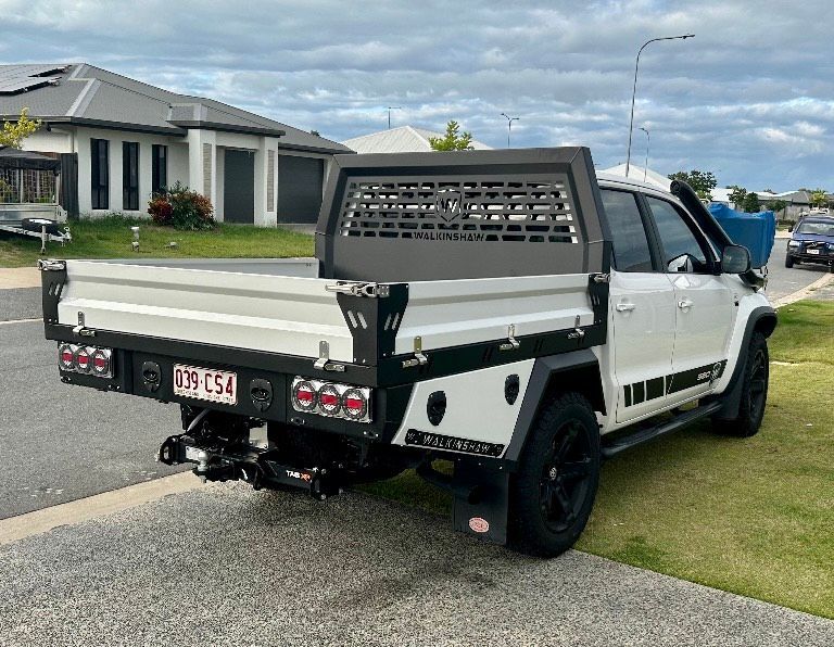 A white truck with a tray on the back is parked in front of a house  — PSE Stainless Steel Fabrications in Manunda, QLD
