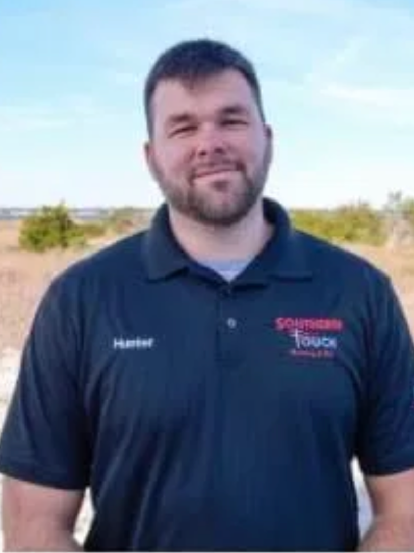 Man in black polo shirt with Southern Touch logo, outdoors.