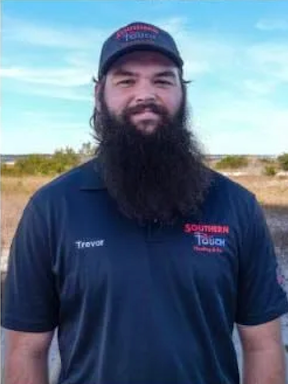 Man with a long beard and a Southern Truck hat and shirt stands outside.