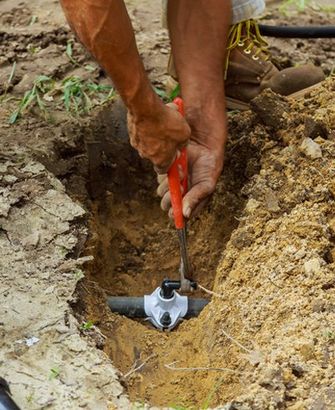Man Working with Pipes in Ground
