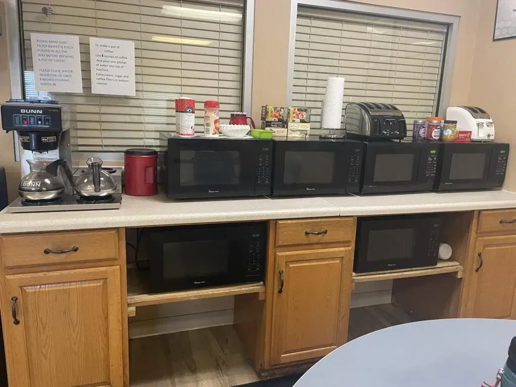 Kitchen area with multiple microwaves, coffee maker, and a toaster.