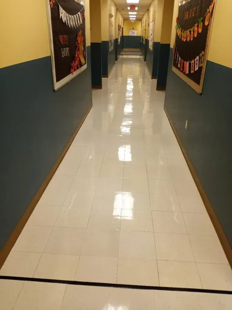 Long hallway with white tiled floor, blue and yellow walls, decorations.