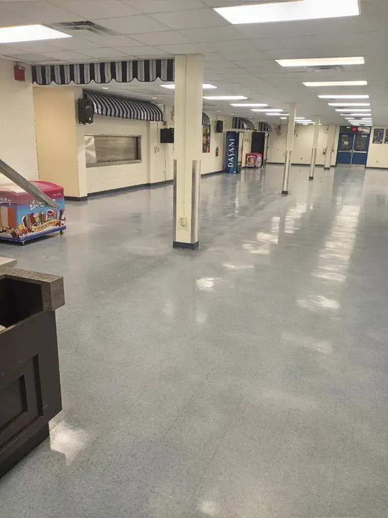 Empty interior, shiny blue floor, white walls, awning, columns, lights.