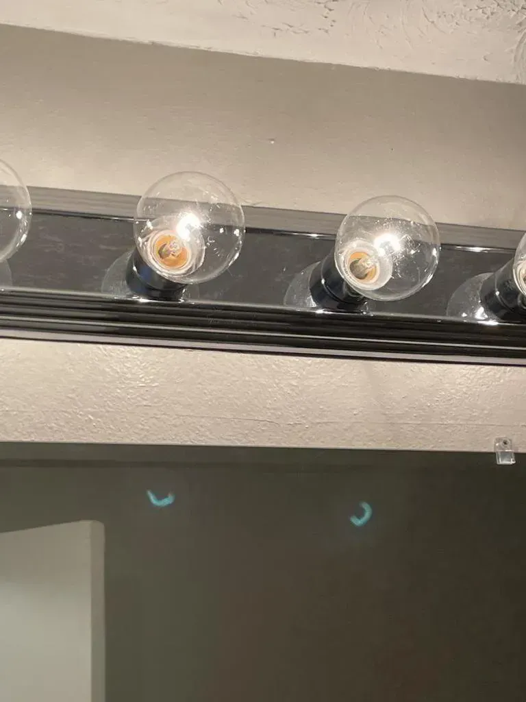 Vanity light fixture with four clear globe bulbs.