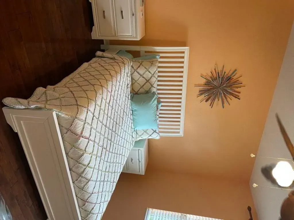 Bedroom with white bed and nightstands; peach walls, starburst decor.