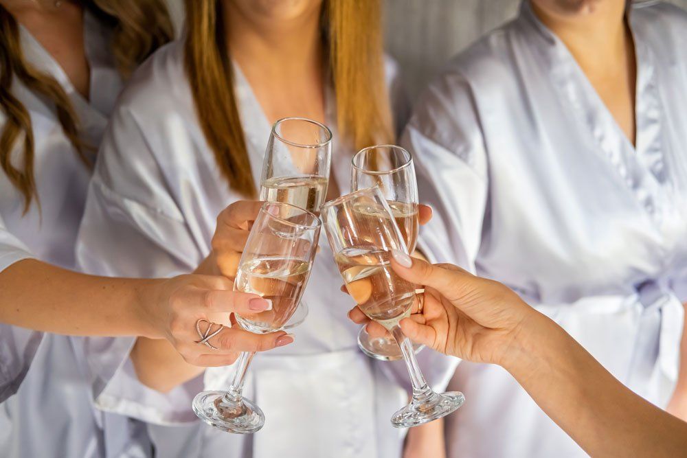 bridesmaids and brides with champagne glasses cheers