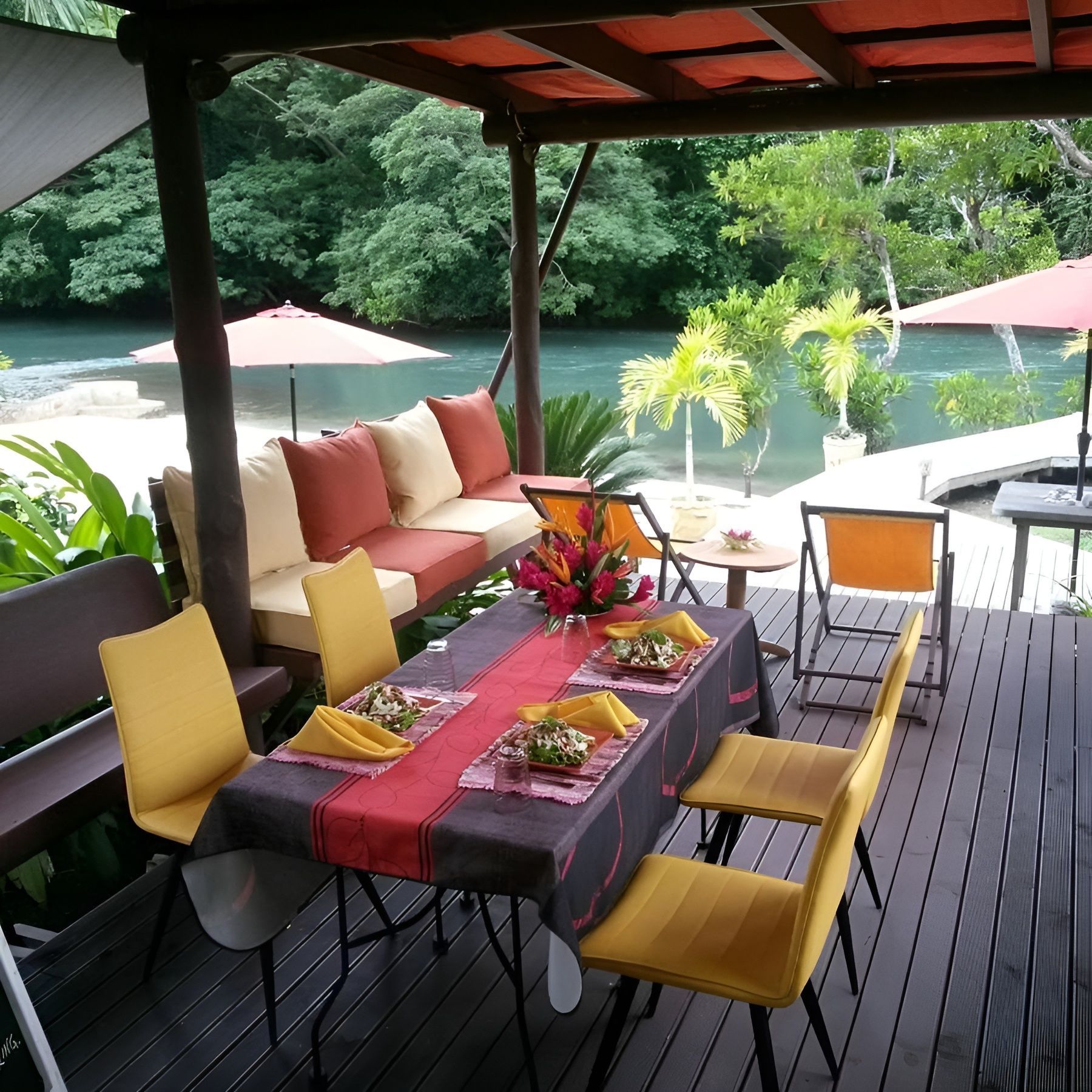 A table and chairs on a deck overlooking a river