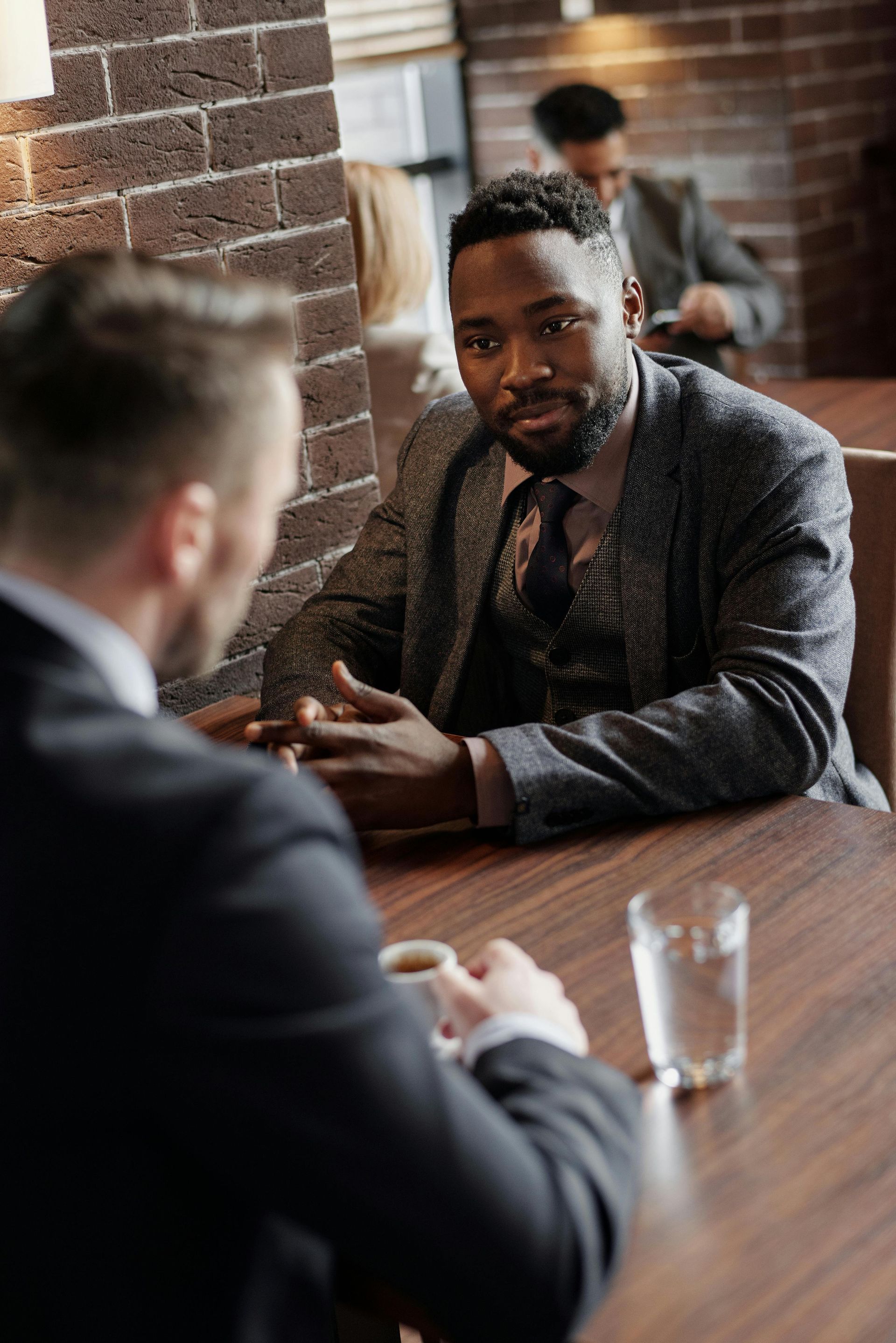 Two business professionals in suits reviewing documents, discussing strategy.