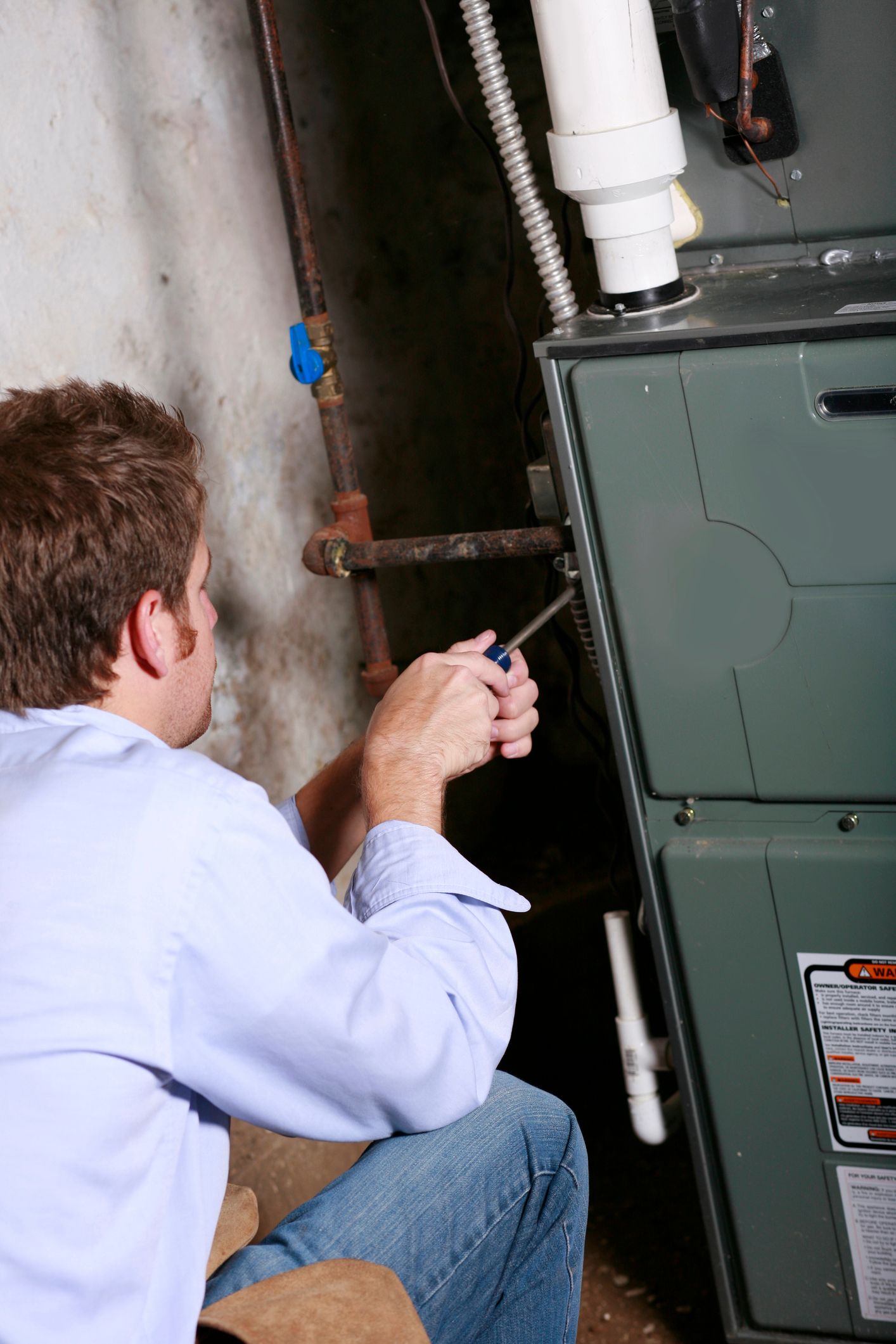 Mr. Air HVAC technician servicing a home furnace in a basement in Etna, OH.