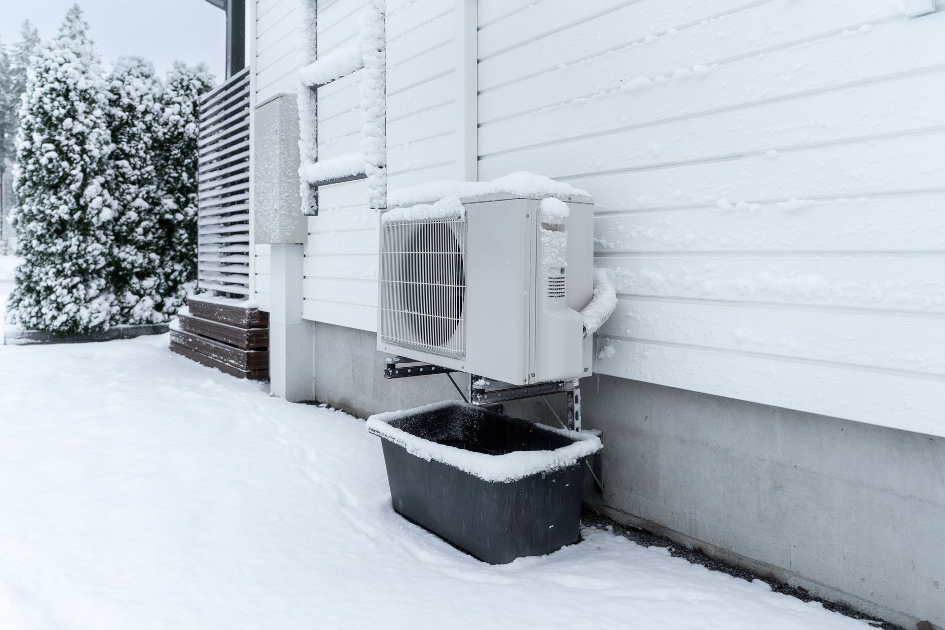 Heat pump outside covered in snow in the Ohio winter.