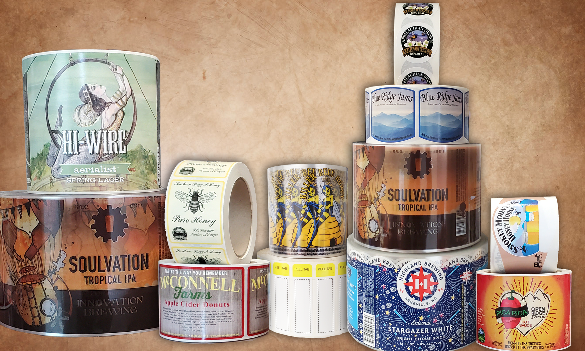 Assorted colorful vintage tins and cans arranged on a tan background, including stacked cylindrical containers.