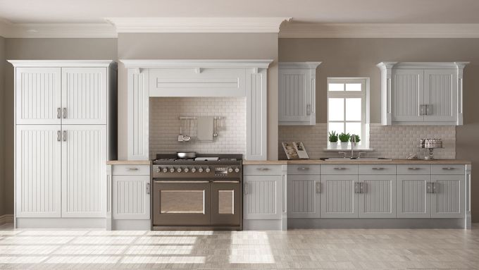 A kitchen with white cabinets , a stove , and a window.