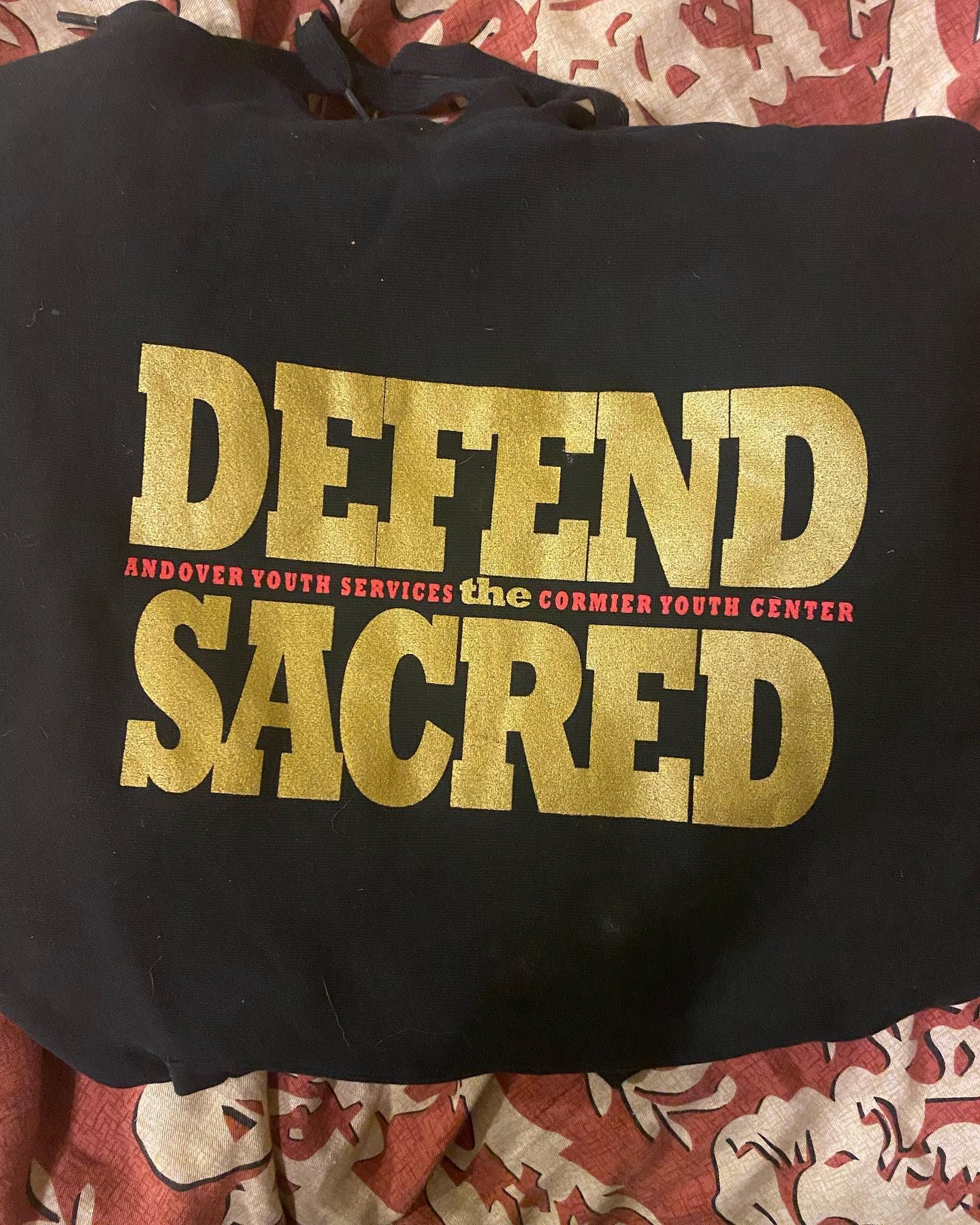 Black tote bag with gold text: