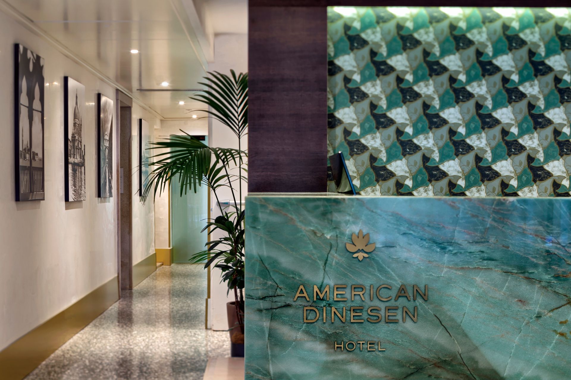 Corridoio dell'ufficio con opere d'arte alle pareti e un'insegna turchese dell'American Dinsen.