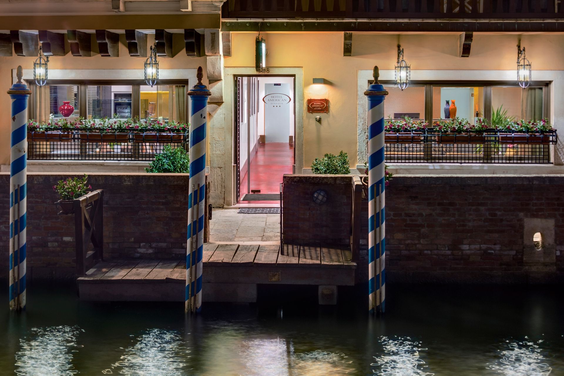 Der Eingang eines Restaurants am Kanalufer ist nachts warm beleuchtet