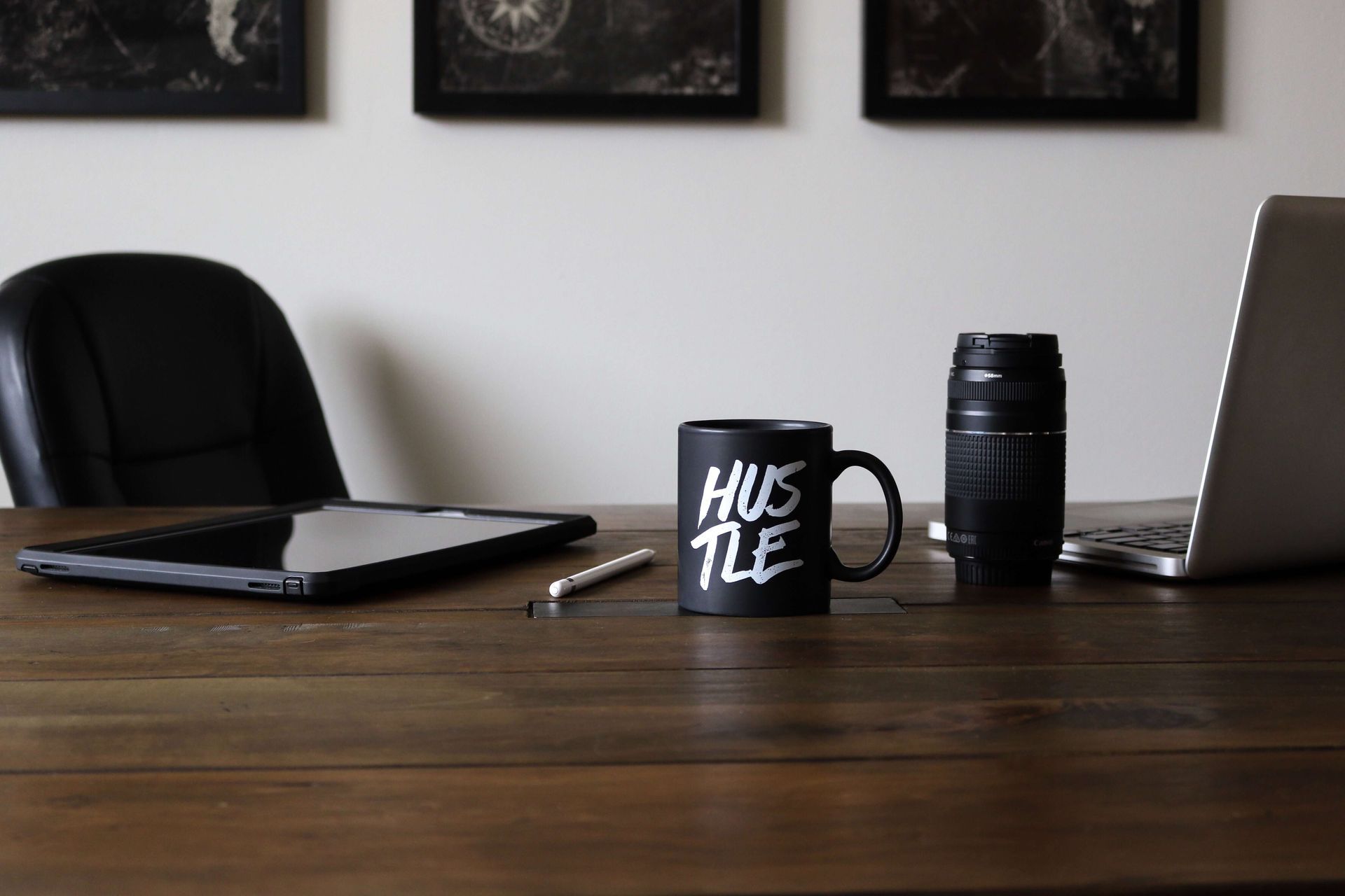 Mug sitting on top of a desk with the word Hustle on it
