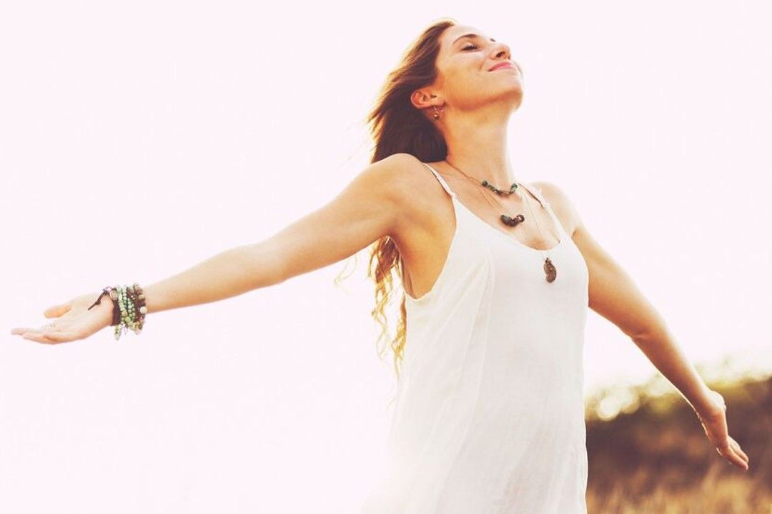 woman standing holding her arms out in celebration