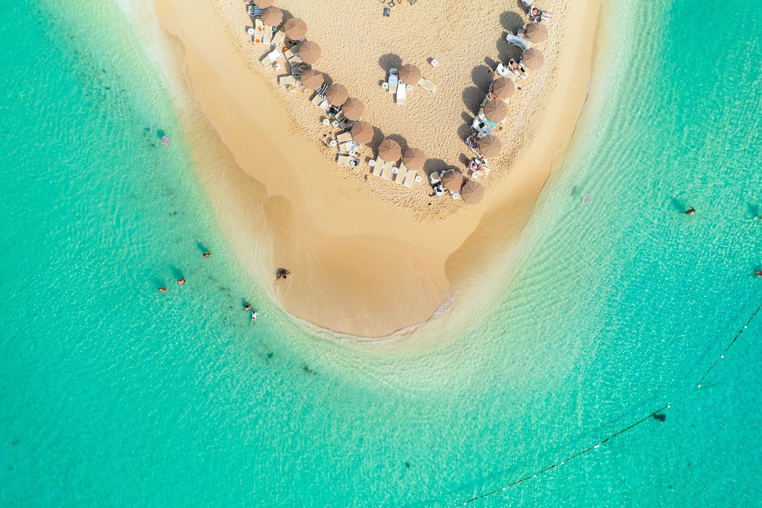 Karibuni beach restaurant on Pinel Island, St Martin, FWI. Beach chairs and umbrellas... by the clear water of the caribbean sea.