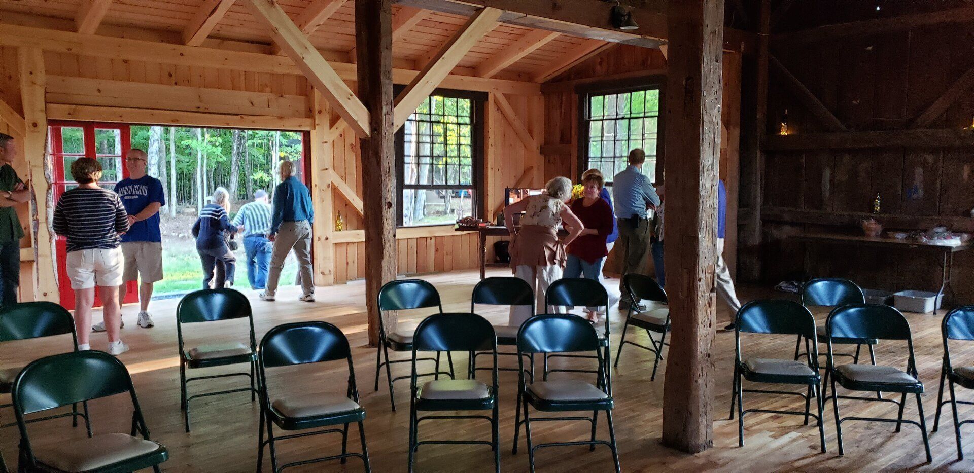A group of people are standing in a room with folding chairs.