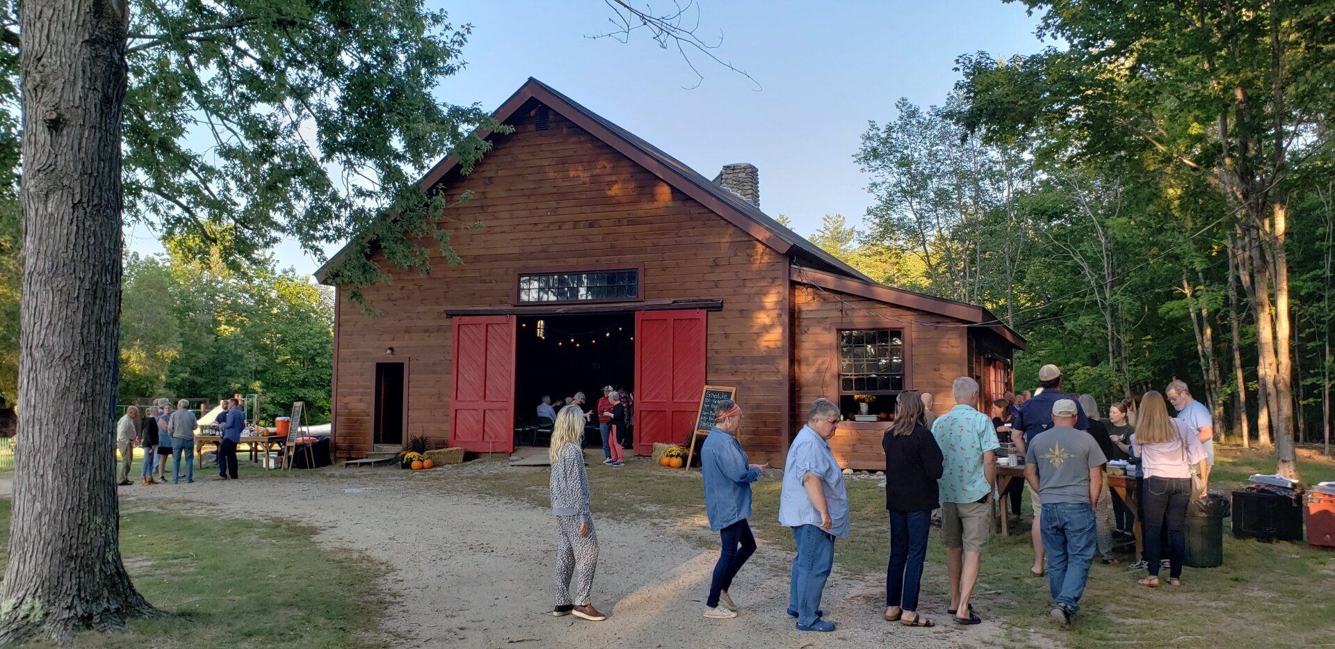 A group of people are standing in front of a brick building with red doors.