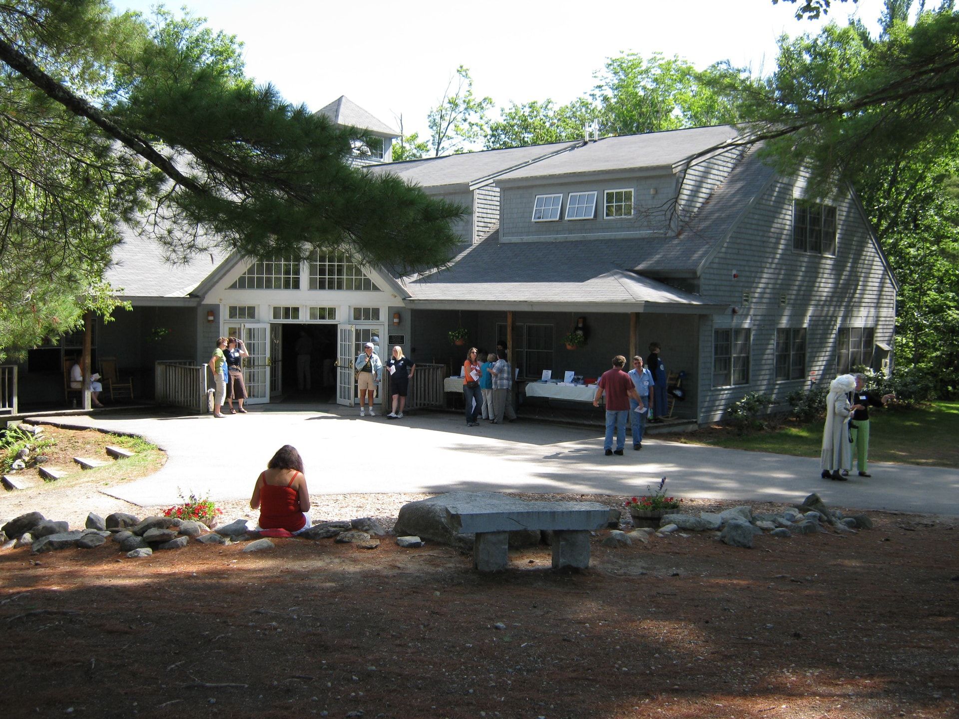 The image depicts the Geneva Point Center in Moultonborough, NH, where a group of team members engage in leadership retreats focused on team building activities. Participants collaborate in various exercises designed to enhance team dynamics and foster a cohesive team culture, promoting effective teamwork and successful team performance.