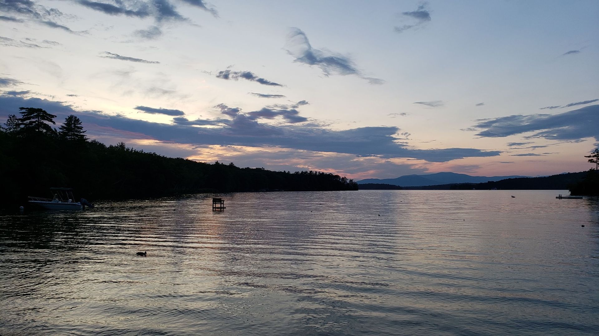 A large body of water with a sunset in the background