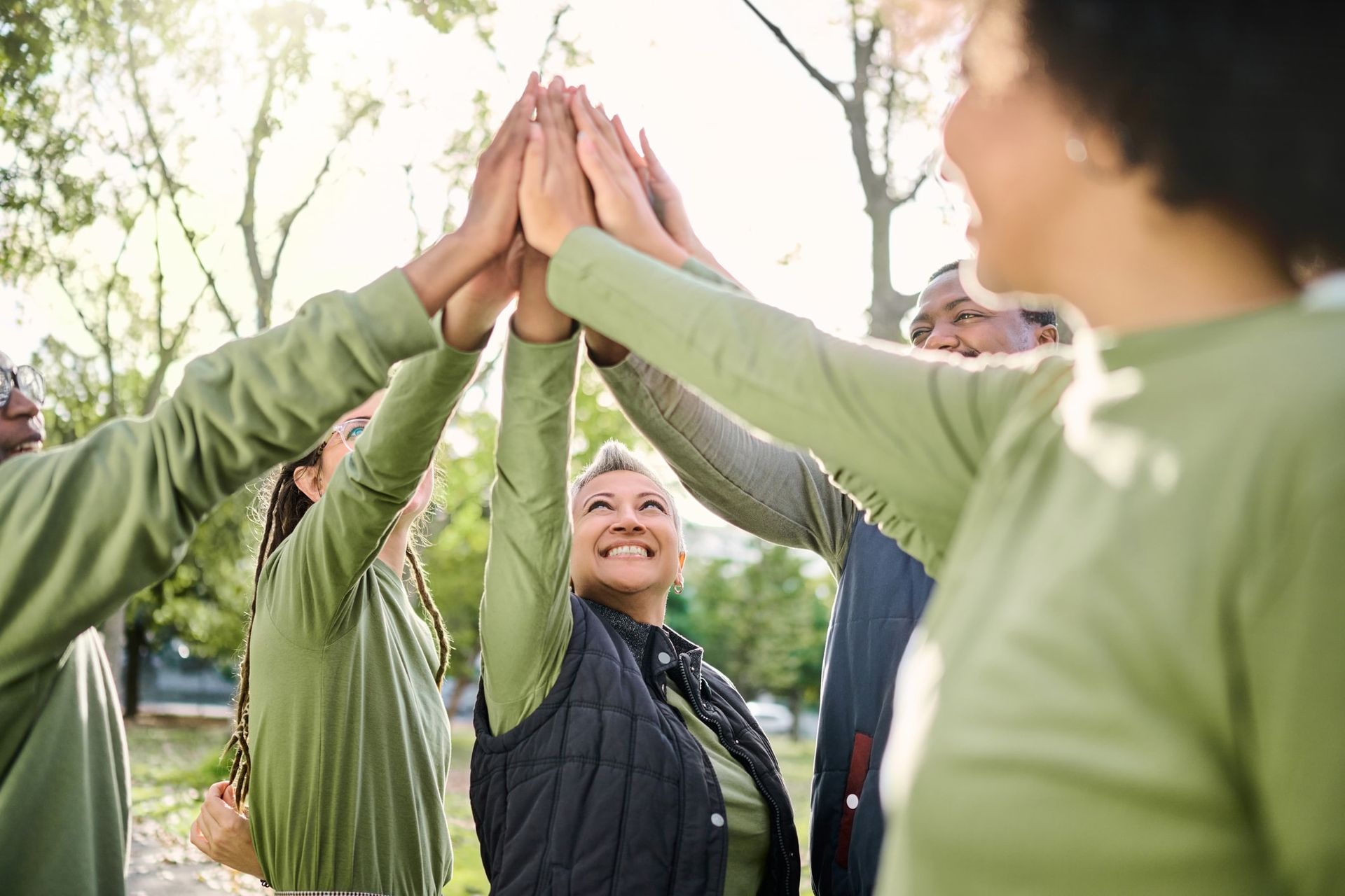 A group of people are giving each other a high five.