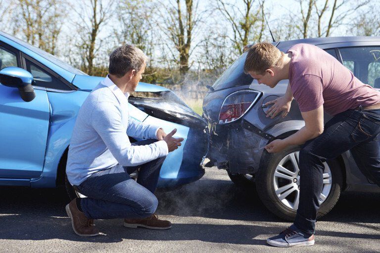 two men next to a car accident