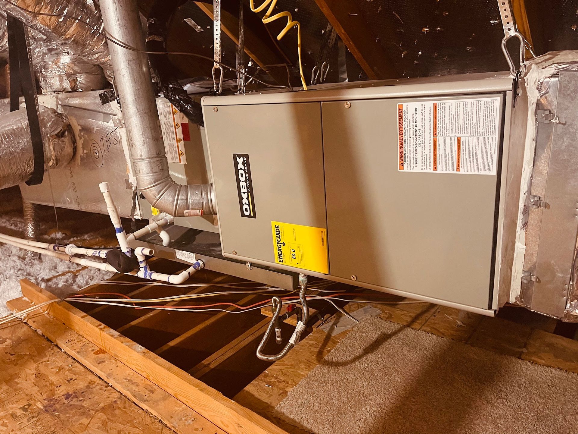 An air conditioner is sitting in the attic of a house.