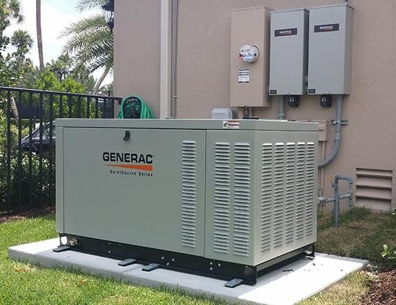 A generator is sitting in the grass in front of a building.