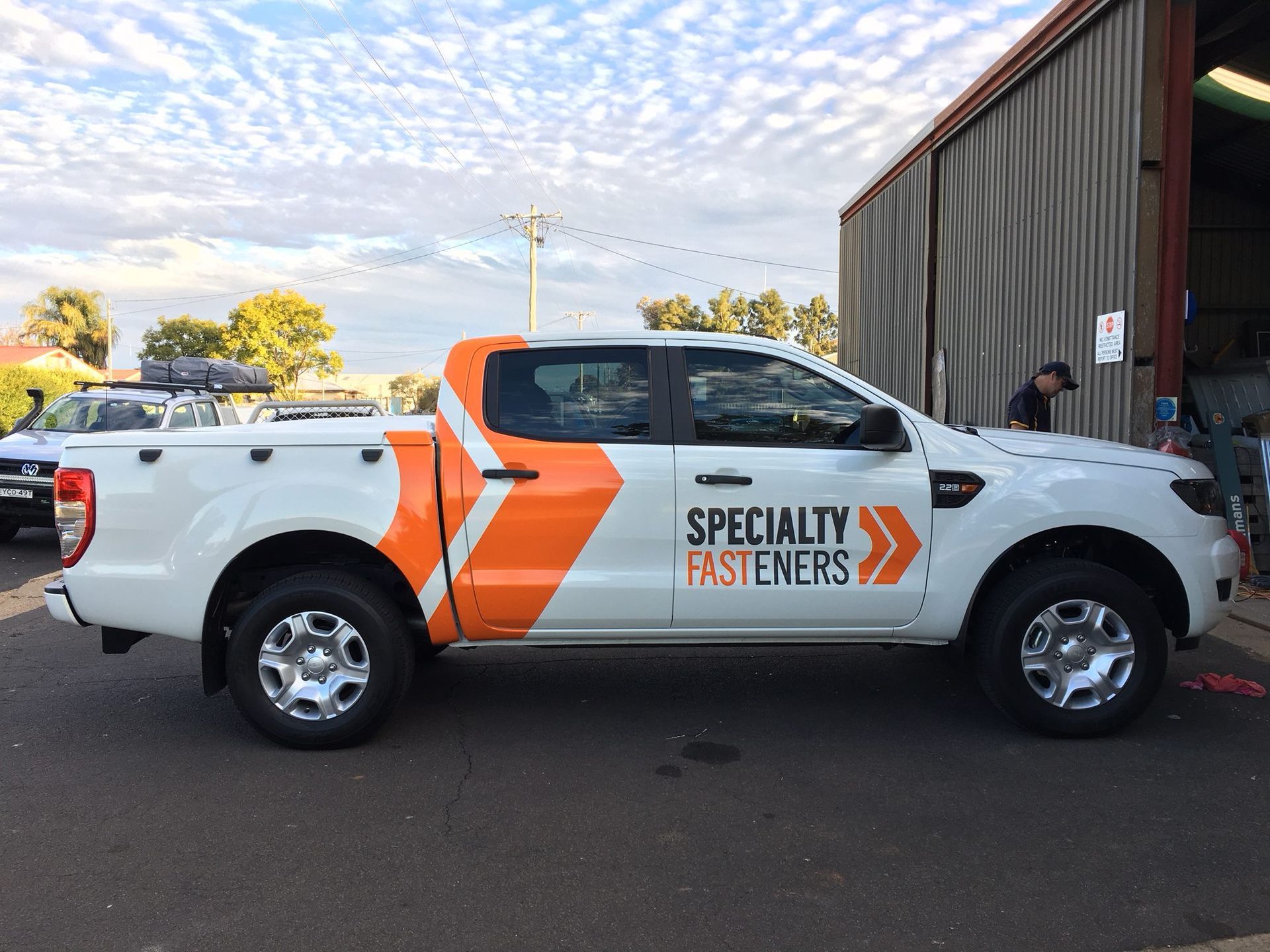 White pickup truck with orange arrow design and