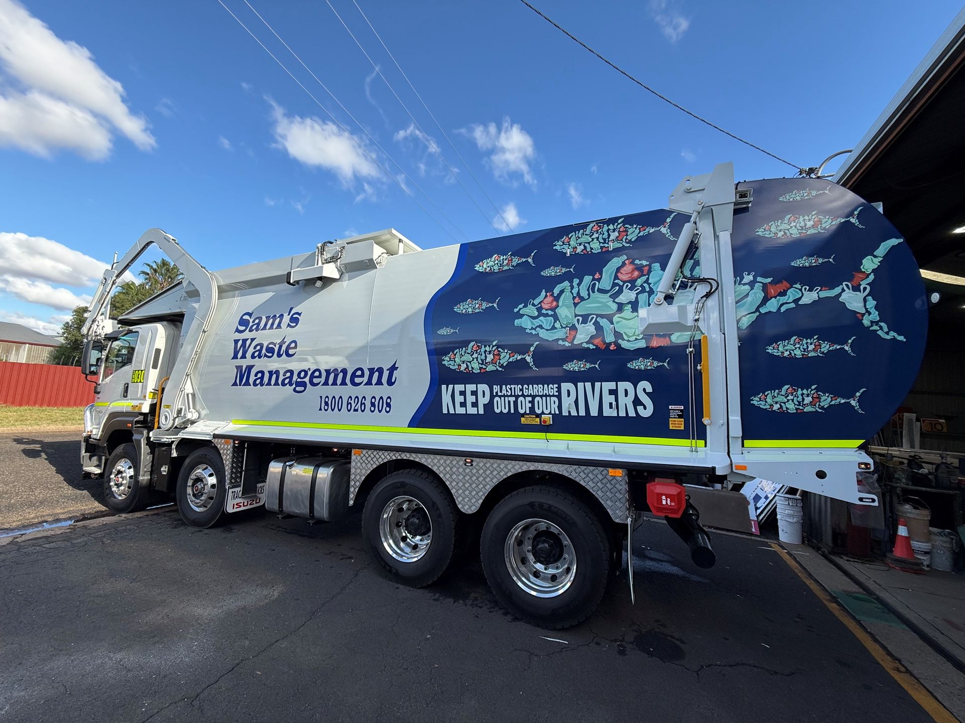 A white and blue garbage truck with 