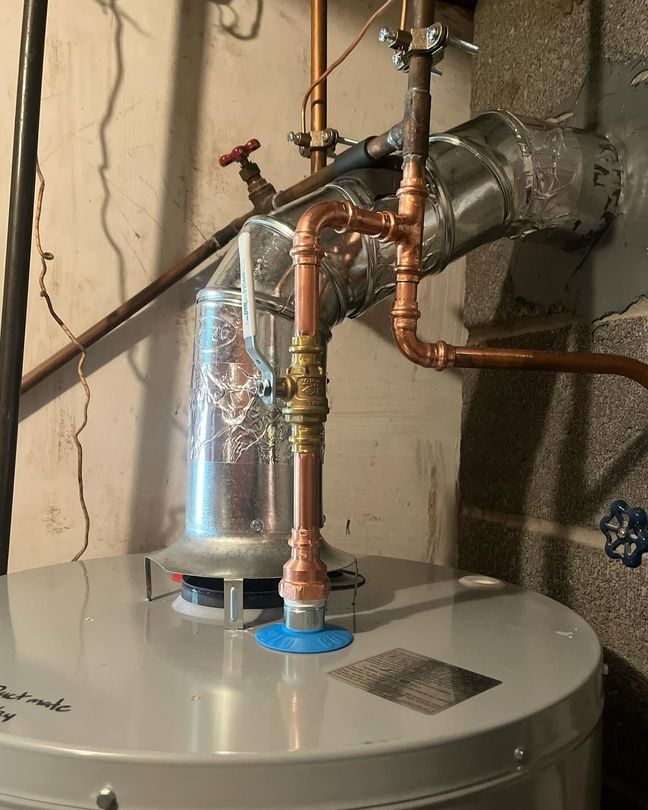 Water heater with copper plumbing and vent pipe in a basement utility area
