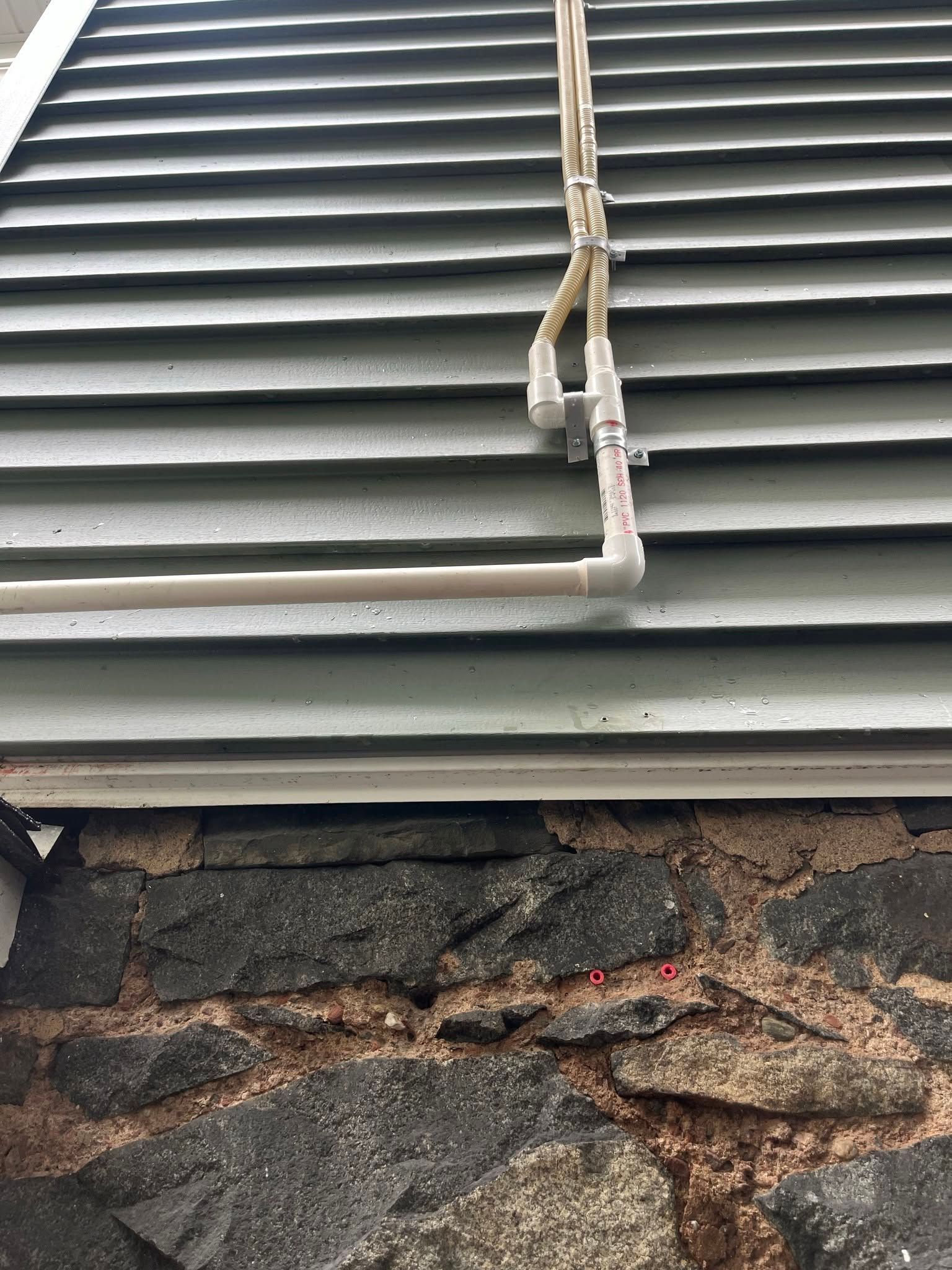 Gray roof shingles above a damaged stone wall with exposed crack and debris underneath Gray roof shingles above a damaged stone wall with exposed crack and debris underneath