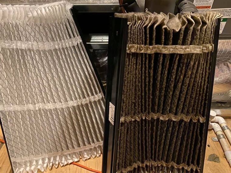 Two folded fabric samples, one light beige and one dark brown, draped over a black stand