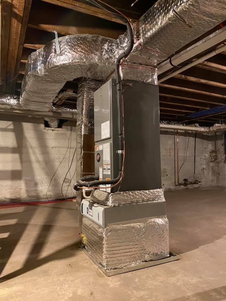 Basement HVAC furnace with insulated ductwork and exposed ceiling beams
