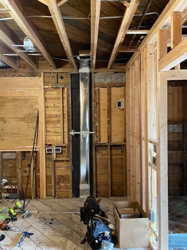 Unfinished room with exposed wood framing, ceiling beams, ductwork, and construction materials on the floor. Unfinished room with exposed wood framing, ceiling beams, ductwork, and construction materials on the floor.