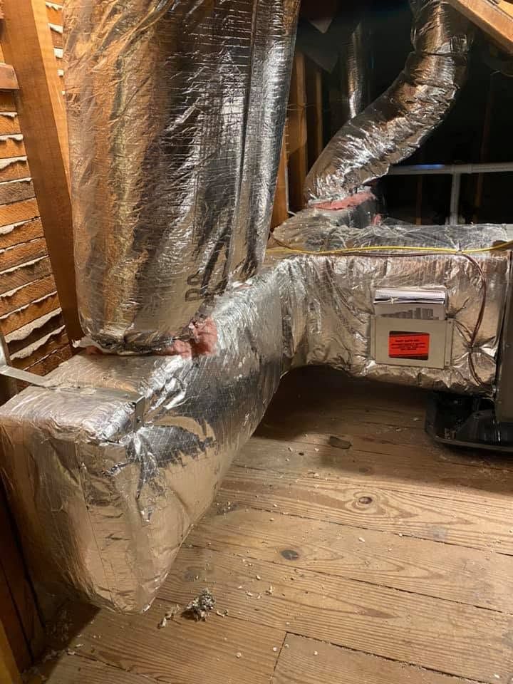 Insulated HVAC ducting and vent pipes in a wooden crawl space under a house