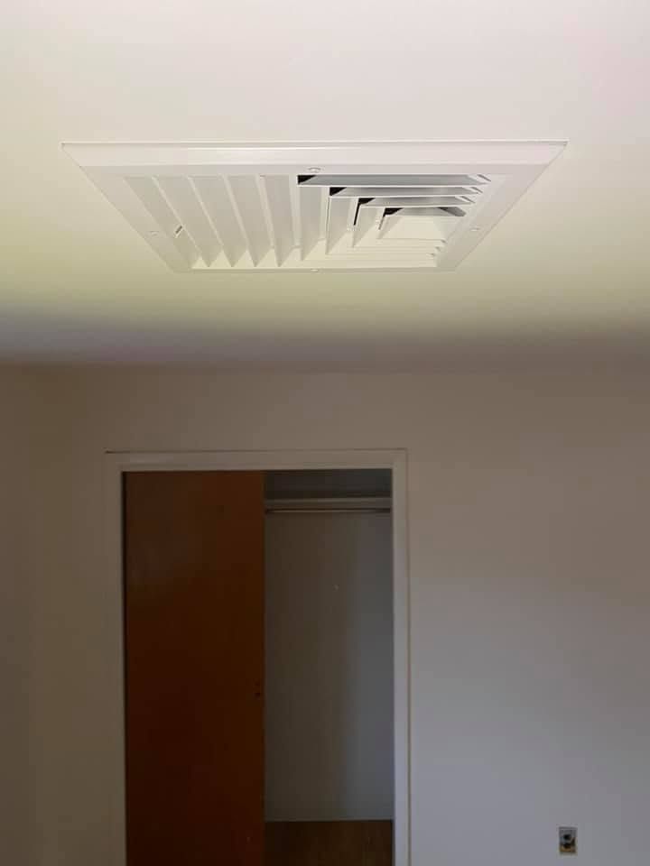 Ceiling vent above an open closet doorway in a plain room
