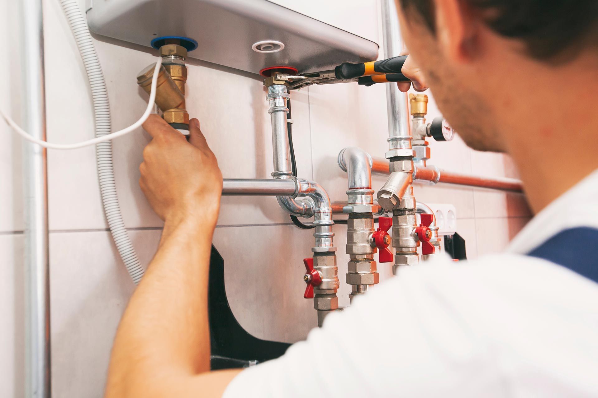 Plumber screwing nut of pipe in the heating system in the boiler room. Plumber screwing nut of pipe in the heating system in the boiler room.