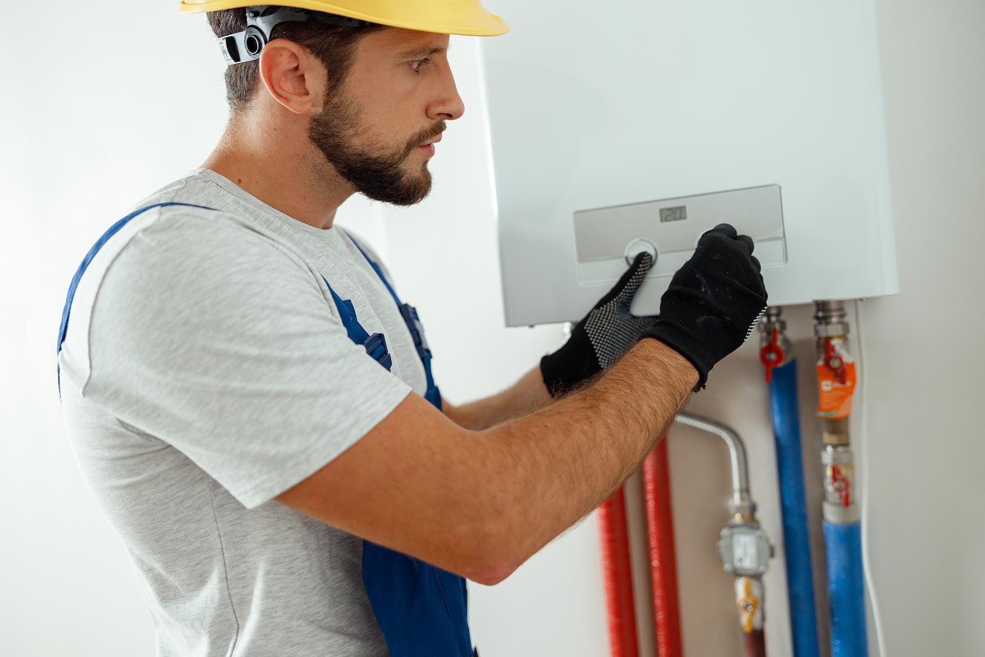 Technician setting the new gas boiler for hot water and heating. Technician setting the new gas boiler for hot water and heating.