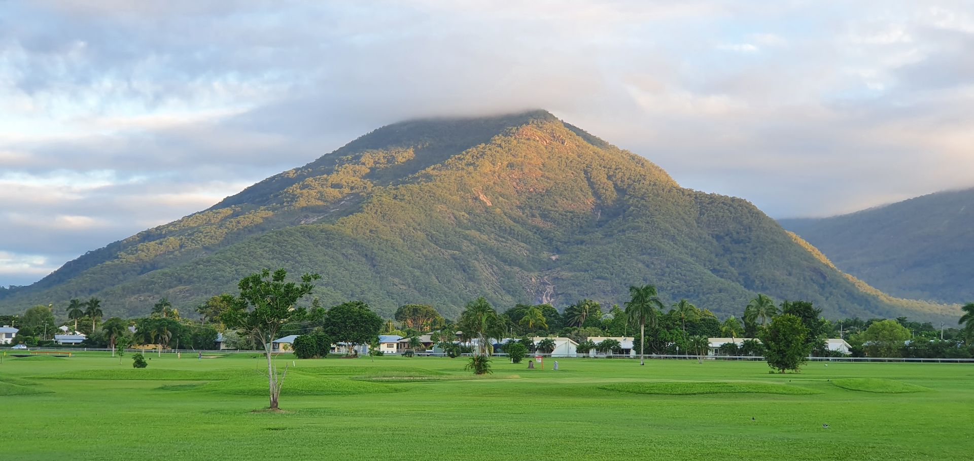 Green Field in Foreground, Houses, Trees — FNQ Smoke Alarms & Maintenance in Gordonvale, QLD