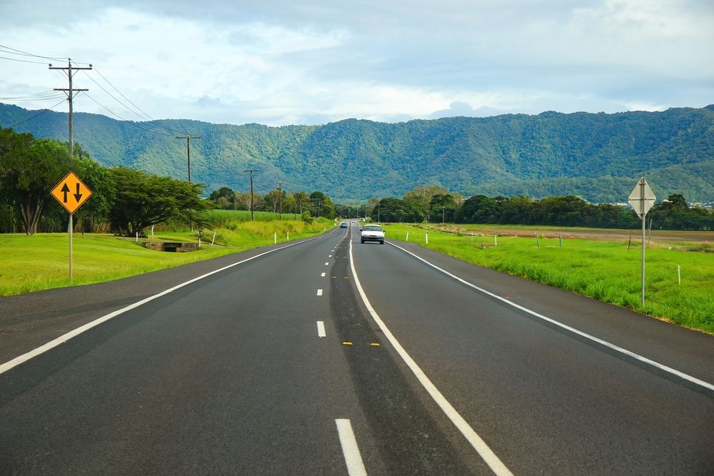 Two-lane Road Through a Green Field — FNQ Smoke Alarms & Maintenance in Edmonton, QLD