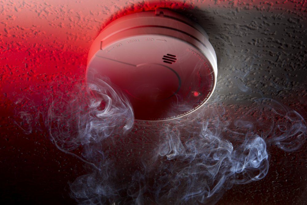 Red Fire Alarm Button in a Store, With a Hand Symbol — FNQ Smoke Alarms & Maintenance in Yungaburra, QLD